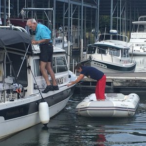 Hoisting dinghy aboard--Bob prepared davit and Marie put in the spreader bar, and will attach the Garhauer Davit carabiner to the spreader bar.