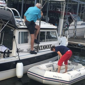 Ready to lift, Marie will come aboard into the cockpit and then go forward to help guide the dinghy onto the top.  The dinghy is hoisted bow aft, so the tubes will go under the radar arch, as it is rotated over the top of the boat with the davit.