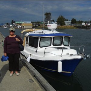 Betty and Our Marinaut at La Conner.  Please take a look at the front, starboard window.  It is so wide, that I can easily hang out the window to set the midships fender and docking line to the dock cleat.  It's not just my arm -- I can comfortably hang the entire upper part of my body out the window to set the line and fender.  This has greatly made docking easier.  What a great design!

Shown also are the privacy, snap-on canvas curtains in the front windows