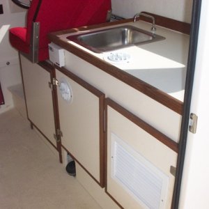 The Mermaid Marine AC (www.wrightmarine.net) works great!  Craig hooked it up and we run it with a Honda 1000 generator, or shore power, either one.  Note the return air vent and two cool air vents.  The cabinet door can be opened to direct the air into the bed area.