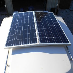 I used this idea for several years and realized 200 watts was overkill for me.  I remounted one 100 watt panel on standoffs on the middle of the roof.  This clears the hand rails and looks neater.