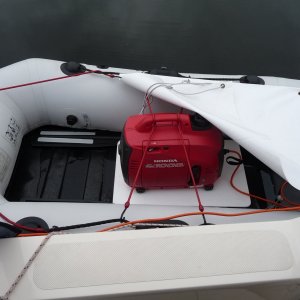 Media '5. In rainy weather I put the 3-1/2" thick foam seating pad that I use normally in the dingy, under the 1/4" white plastic sheet the generator sits on to give it more distance off the bottom of the dingy. The white tarp bungy cord's on above the generator to protect it from the rain.' in album '1. I put this 1/4" sheet of plastic down to protect the bottom of the boat while the generator is running and give a more stable base for the 1000 watt Honda Generator to sit on and also protect the bottom of the boat.'
