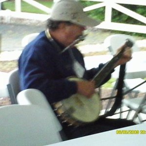 Tom McHugh playing banjo and harmonica