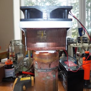 This is a thermo-electric chip (TEC) with an air cooled copper heat sink salvaged from a computer on top and a length of 1.5" copper pipe filled with antifreeze on the bottom.  It is stuck together with thermal epoxy.