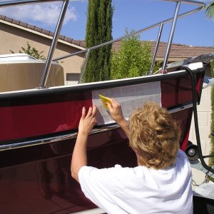 Marilyn smoothing out the surface after soapy water solution applied to letters and boat surface