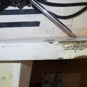 Transom under trim strip shows damage and evidence of past repair. The black plastic strip was missing and a previous owner tried to seal the evident junction between core and fiberglass with epoxy.