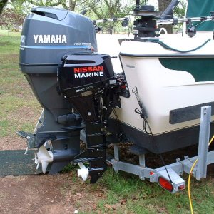 Nissan 8hp kicker with stainless tie rod to slave off the main for helm steering.