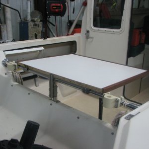 Cabin table hangs over tubing via stock wall tabs. The rod holders act as side stops. No modification needed.