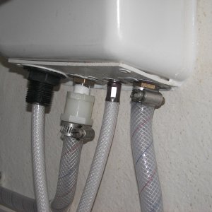 Long nylon fitting kept pulling off center, causing leak. Finally just heated the hose and clamped it directly to the shower hot faucet input threads. The back, left shows the original nylon fitting on the cold faucet. The back, right shows the hose clamped directly on the hot water faucet threads. No leak now!