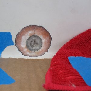 Media 'A perfectly circular crack in the the center (athwartships) of the splashwell gelcoat  turned out to be a "phantom" drain that had been drilled for but then simply filled and gelcoated over, presumably at the builder or dealers.  Subsequent conversation supplied me with the info that the center location was typically used for twins (my boat has two engines, but not twins).  This type of "repair" (just filler and gelcoat) is destined to crack, which it had.  I ground it back in a taper to prepare for adding fiberglass cloth.  Actually here I had taken away too much of the fiberglass (pink bits) and so ultimately I increased the diameter and improved the taper (leaving more glass to bond to), but I don't have a photo of that.  This gives the idea, anyway.' in album 'Brass splashwell drain tube removed. I used a hacksaw blade and cut three slits (through the tube lengthwise), then dented one edge in with a cold chisel and grabbed it with vise grips to pull it out (not hard since it was barely sealed).'