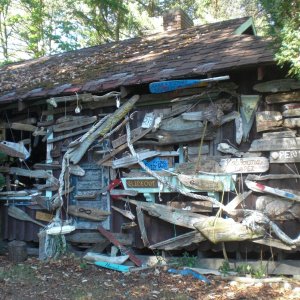 Visiting boats hang their boat name on driftwood on an old cabin, Conover Cove.