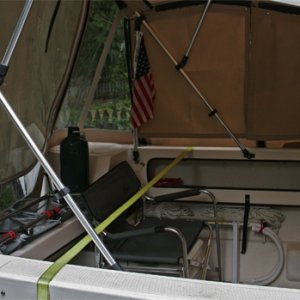Cockpit with camperback starboard panel removed. Transom bars are most useful mod yet; holds cooler, net boxes for propane / water jugs, fenders, rod holders, etc. Chair just fits over potti to optimize space. Shower enclosure and sunshower makes a handy addition to cockpit.