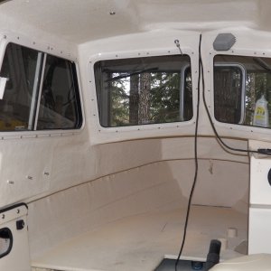 Once dry, it gets sprayed with an off white paint that is fairly close to the gel coat color.  The surface of the rubber paint would attract too much dirt.  Notice the black conduit hanging down.  Black wiring was strung all around the boat.  I can fix that.