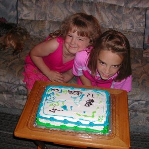 Claire and Grace Callahan (OTTER) decorate a blue/green C-DORY Cake.  Note the loose tooth!  Is it gone yet Grace?
