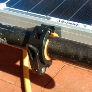 I used these cool little quick release clamps I found on Amazon. They're actually bicycle handlebar clamps to mount a flashlight.

This makes it easy to swap the panel to the roof rack on the truck when we want to go out boonie crashing.