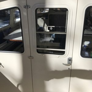 Locking cabin door has sliding window and screen.