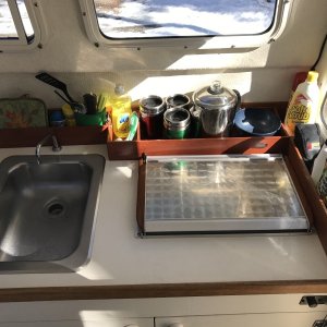 Stainless steel sink, faucet with foot pump, Wallas 95D diesel stove/heater and custom made wood storage racks.