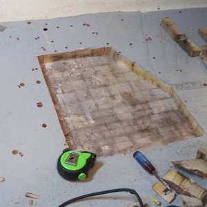 Here is the extent of the removed balsa.  You can see by the strips at the upper right how much I was expanding with each cut.  The moisture was mostly against the lower laminate and when I no longer found structurally compromised wood, I stopped.  Well, first I drilled some outlying holes to examine and, since they were okay, I stopped.  I decided not to remove the core to the black hole at the top of the picture because the wood in between it and my major area was okay even though wet.  The moisture reading in the wood was 37%, which is basically saturated but not dripping wet.