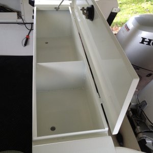End view showing drain holes in the bottom. Attached to them is a hose that drains outside of the boat.