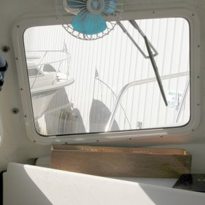 PIX shows the port side original 11.5" SS Deluxe wiper with the replacement arm. The new 14" wiper is now installed. It's adjusted parallel to the outside edge of the window and centered in its height.