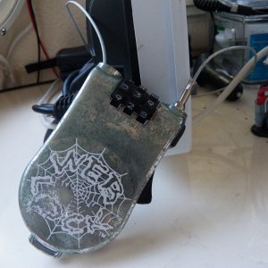 This is a little plastic-coated stainless wire combination lock generally used to keep people from walking off with your laptop or skateboard.  I bought a lot of 10 cheap on Ebay and use them for electronics, etc.  Good wire snips would cut it, but not a pocket knife or a hard tug.