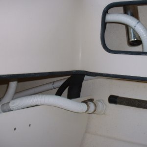Media 'Water from the pump flows through the hose that bends by that rod holder and enters the tank. The other hose is the drain that is continuously discharged overboard.' in album 'Here are some photos of the live bait well plumbed into the port laz by the dealer for the previous owner. The clear hose with check valve on the left is the intake for the manual bilge pump. This photo shows the bait pump with bronze through hull and valve.'