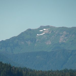 Melting snow leaving smiley face on mountain, Gambier Bay
