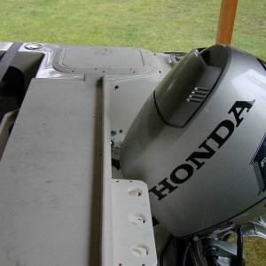 Transom storage box with one of the engines in the upright position.  There is still over 2 inches of clearance left.  Also shows extra net and pole holders.