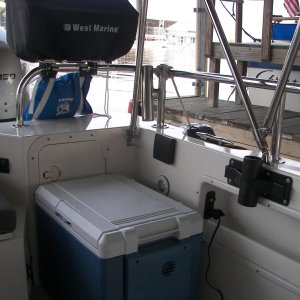 Media 'View of 12V Fridge, double 12V outlets, cup holder, 4 inch cleat on side of baitwell to strap cooler in place in rough water or on highway, Magma Newport grill which holds all the accessories inside, and gas cylinder holder bag.' in album 'Perko rod storage area'