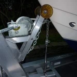 P1000487 The turnbuckle is only hand tight and it holds the bow down tight. The lock nut on the turnbuckle wonders down and it will not let the turnbuckle loosen up. The aluminum angle underneath that the ubolt is bolted thru is below the top flange of the frame rail. Hopefully preventing a close relationship between boat and truck and it's occupants should the unthinkable occur. Looks and works better than a stinking strap
