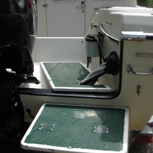 "Bridge over the splash-well from the swim step to the cockpit of boat.  3/4" plywood, epoxied & painted.  Green paint has sharp silica sand for traction.  Bridge must be kept slid to outside when boating.  You can see crunch on white edge where hydrolic steering arm crunched it when it moved too far to the center of the boat.  Note large "Sierra" fuel filter.  Filter which came with boat gave problems and left me to be towed in one time.  I replaced the original filter with this inexpensive one that still filters out water.  I replace filter canister yearly and no problem for last 6 years.