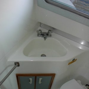 Bathroom Sink and Storage. Shower wand and hose snap onto faucet spout.