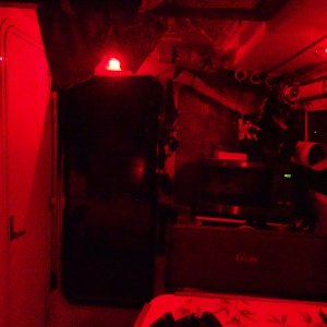 Looking aft, red lights above door, and in the light fixture over the aft dinette seat (white there for reading also)   One of the two cabin door screens is in place.