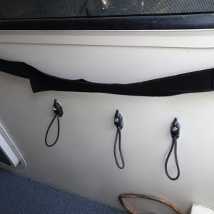 strap on top holds folding chairs in place.  Bungee cord holders for dock and extra docking lines.  One from bow, one from amidships cleat and one extra line.  Also in aft cockpit is a single similar bungee attachment for each stern line