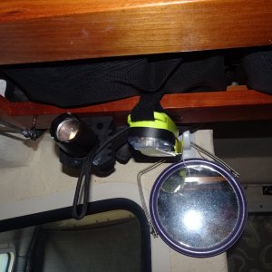 Flashlight and PLB are right above the galley.  Mirror hangs form clips.