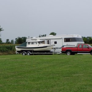 Boat and Truck Parked Alongside Fifth Wheel Trailer