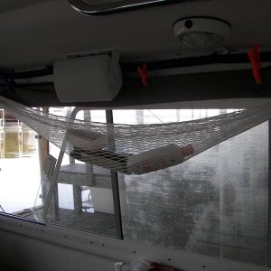 My boys don't like the gear hammock, but it keeps things from flying around in rough water and easily comes down. The plastic clips hold the window covers up and corrects that middle sag when down.