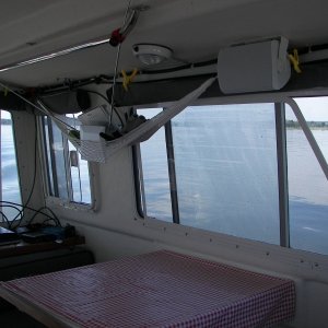 Polaroid flat TV down on the cabinet and the inside antenna looking strange in the hammock. That is because I cannot get TV reception under the metal dock housing unless the antenna is low...  maybe change some day. But, the 'curtains' look good!