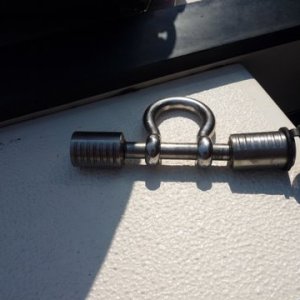 Drilled out shackle to fit a trailer pin lock, chain slips onto shackle pin lock goes thru a welded eye mounted to the stainless steel plate