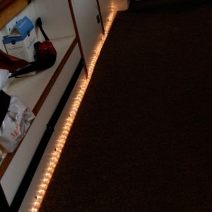 Media 'LED-Rope-Floor-Lighting' in album 'Copilot storage made from lucite sheet cut, heated and formed into a simple L shape. Mounted to forward bulkhead and seat box. Teak trim stiffens and covers the top edge.'