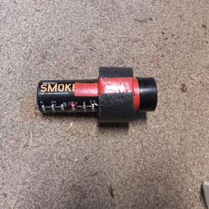 The piece of foam is taped on, leaving enough room so that it can still be hand held.  The foam keeps it upright if thrown overboard, which is what I would do.
