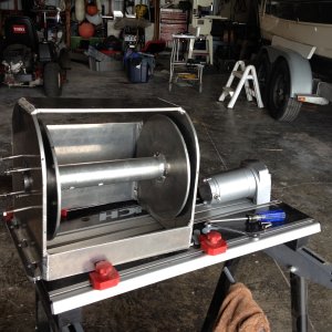 Winch half done. The winch motor is just a 2000 lb cheapy winch that you can pick up on Ebay or locally. Cut the winch drum in half and remove the nylon bushing from the steel plate that supports the outer part of the drum. Cut a hole the bushing will tightly fit into  in the port side of the shell. When you mount the motor on the other side, it has the bushing in it already. Remove the 4 small screws from the winch and drill the holes out to 1/4 for the bolts that will hold the motor on.