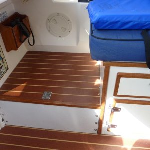 Storage area under the raised deck at the front of the helm seat.  Easy access for navigational items.