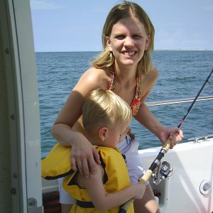 Oldest daughter nurse Beth and Grandson Tennison slapping a fish on the boat