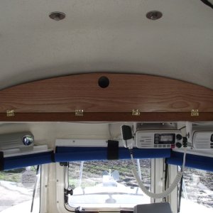 Overhead cabinet door held closed by magnetic catch