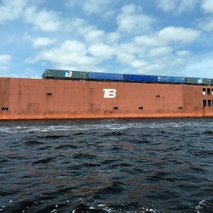 This cargo ship was being loaded with semi trailers.