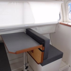 Media 'Dinette w/Nav seat facing fwd; storage in box and floor below; window curtain rolled down' in album 'Dinette w/Nav seat facing fwd; storage in box and floor below; window curtain rolled down'