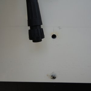 plug of depth sounder transducer by pilot hole in transom.  Pilot hole to be sure that the larger hole will not cut into the splash well or fuel tank.