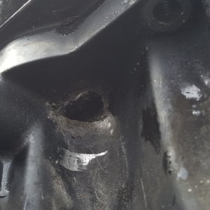 Quarter-sized corrosion hole underside of oil pan.  Notice the light gold colored replacement plug.  Didn't help.