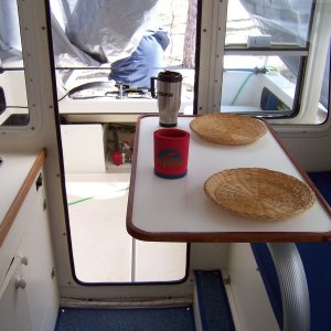 Media 'There is still room to work in the galley and pass fore and aft.' in album 'C-Swell did not have a table so I decided to add a Garelick stowable table. I added cherry wood molding made by my Dad to keep things from sliding off and to go with the other wood trim in the cabin.'